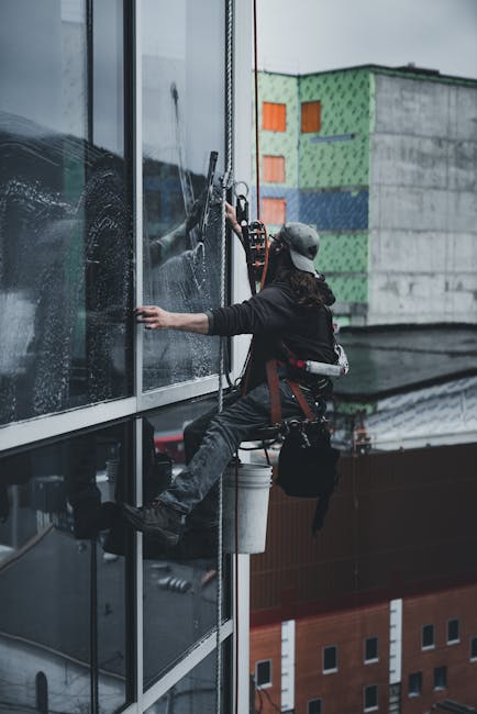 pexels-photo-17041924-17041924 A man in a harness cleaning skyscraper windows with precision.