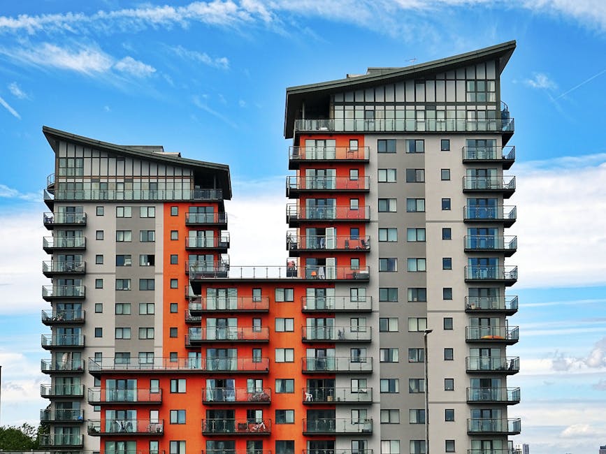 building maintenance man Modern high-rise apartment buildings with unique architecture under a vibrant blue sky.