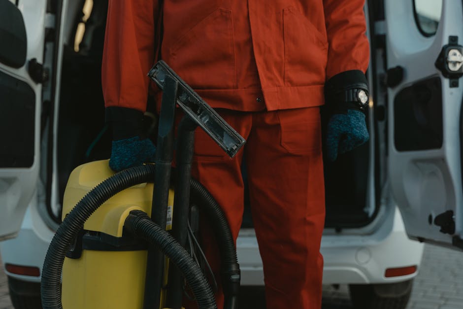 commercial cleaning services tunbridge wells A professional cleaner in a red uniform holding a vacuum near a van, ready for service.